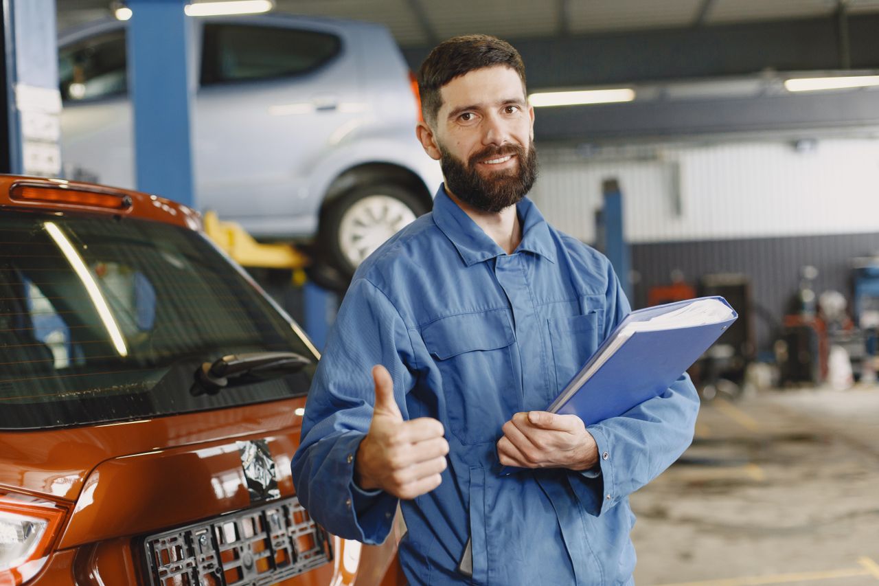 Mastering the First Impression: Your intriguing post title goes here Auto mechanic in blue coveralls with clipboard giving thumbs up in garage.
